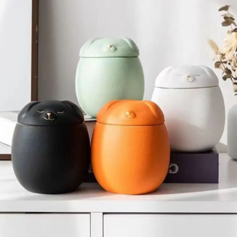 Small ceramic keepsake urns shaped like a dog and a cat